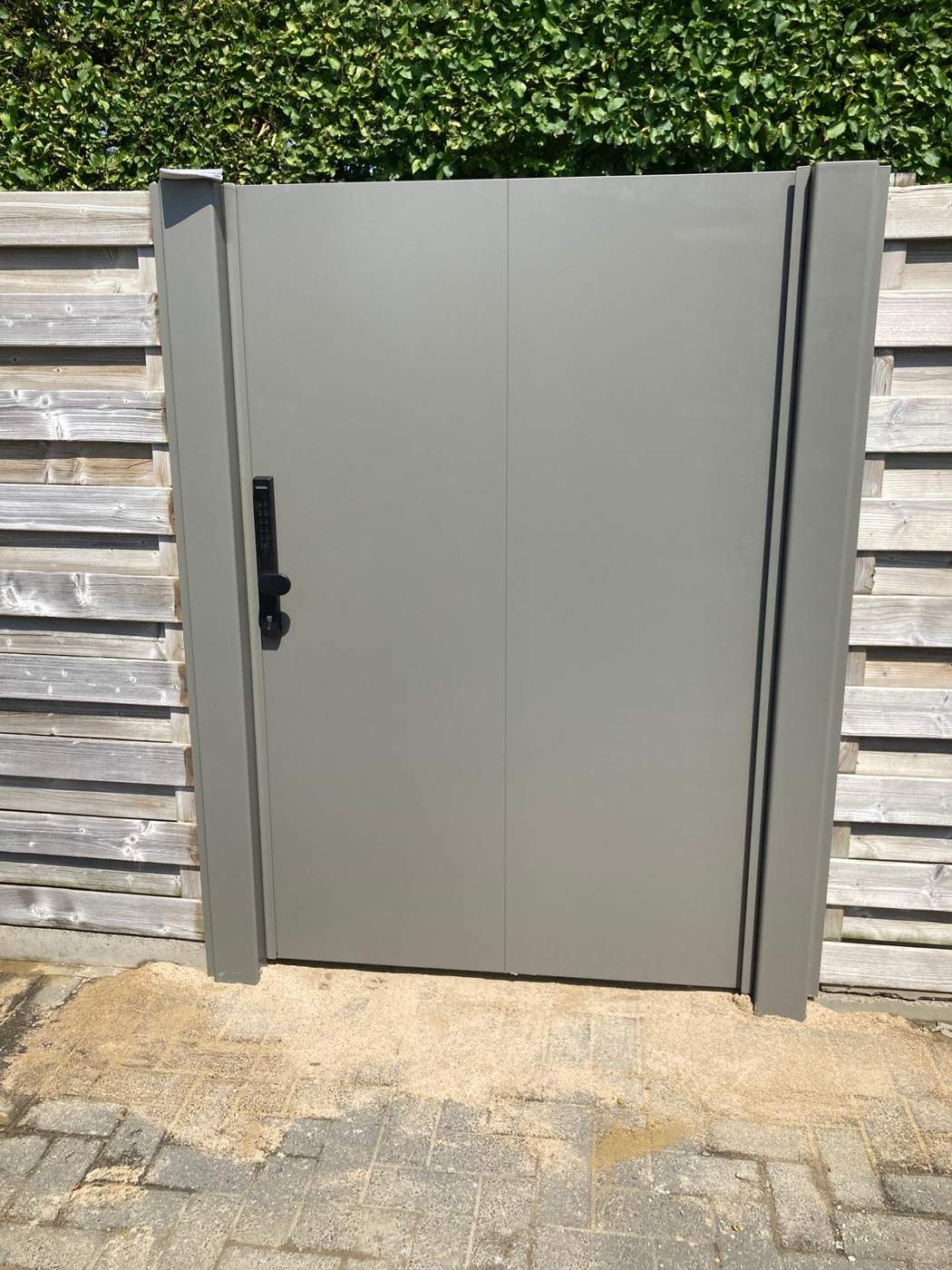 Groengrijze aluminium poort met Locinox elektrisch slot in een houten afsluiting te Herentals